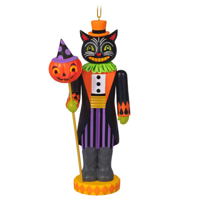 Black cat nutcracker ornament dressed as nobleman with top hat, colorful coat, and pumpkin staff on harlequin base