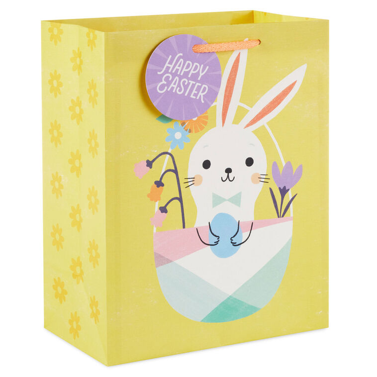Hallmark Easter gift bag with white bunny in pastel basket on yellow background and floral accents.