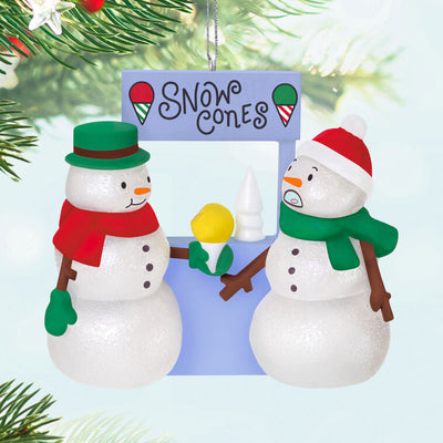 Humorous snowman Christmas ornament offering yellow snow cone to surprised snowperson