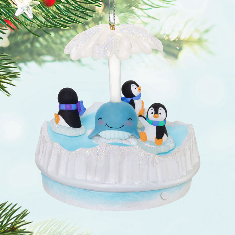 Christmas ornament with three playful penguins spinning on ice pieces around whale, lights and music, battery operated

