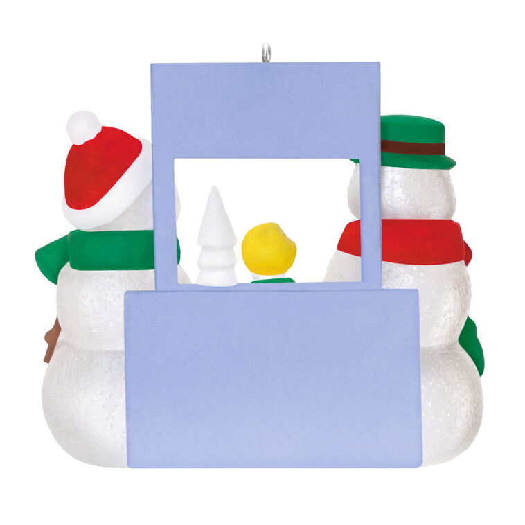 Humorous snowman Christmas ornament offering yellow snow cone to surprised snowperson