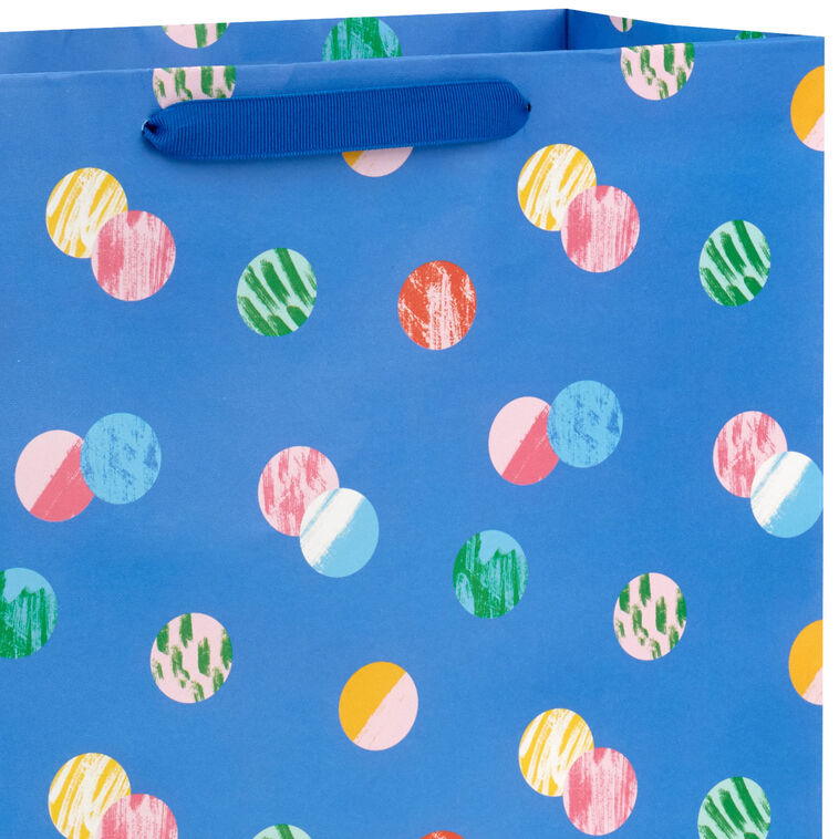 Hallmark extra-large gift bag with playful polka dots on a blue background, ideal for birthdays, holidays, or celebrations.
