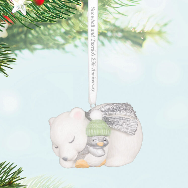 Hallmark Keepsake ornament of Snowball the polar bear cuddling Tuxedo the penguin, white and silver design celebrating 25th anniversary.