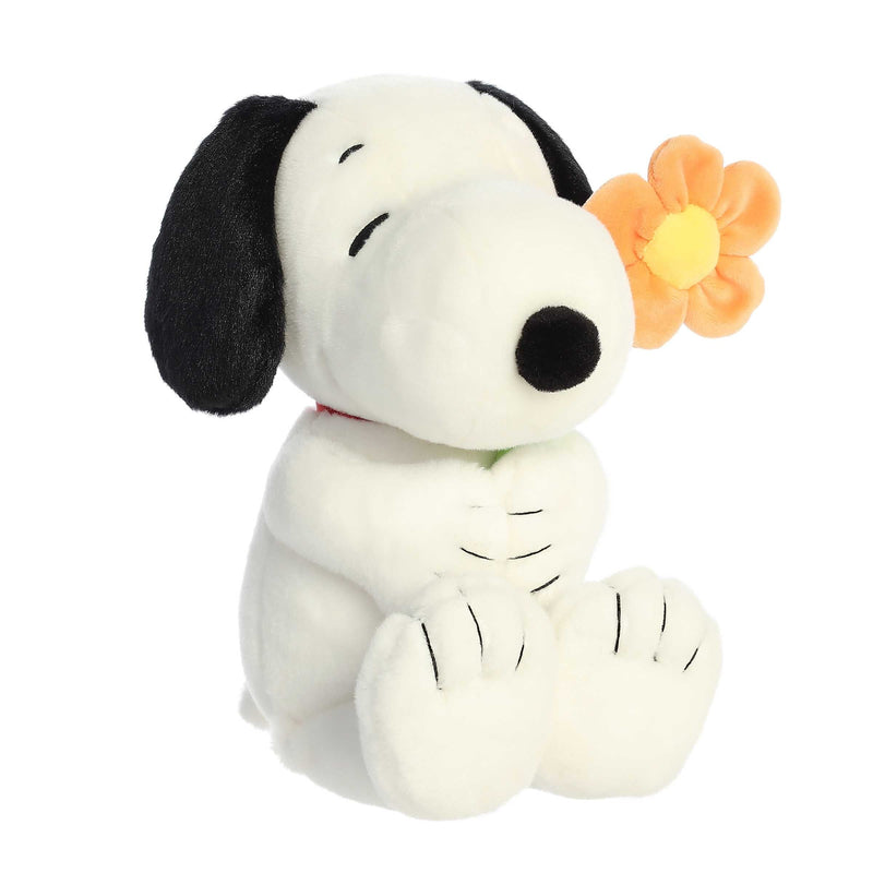 Snoopy plush holding a flower, 11-inch soft black and white stuffed toy from Aurora’s Peanuts collection.