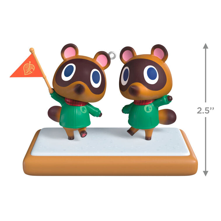 Hallmark Keepsake Nintendo Animal Crossing Timmy and Tommy ornament, twin raccoons with flag, green jackets, red scarves, on wood-style base.