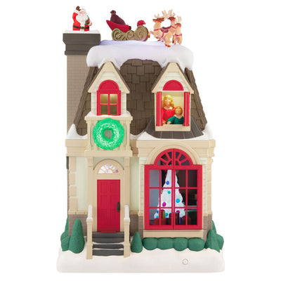 Christmas decoration showing Santa dropping down a chimney with lights, motion, and music from Up on the Housetop

