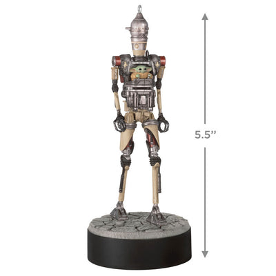 Ornament of Grogu piloting IG-12 droid from Star Wars: The Mandalorian™, on round base with sound button for “Yes” and “No” phrases.