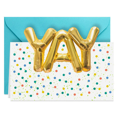 White note cards with gold balloon-style “YAY” lettering, confetti dots, and die-cut front, packaged in kraft wrap.
