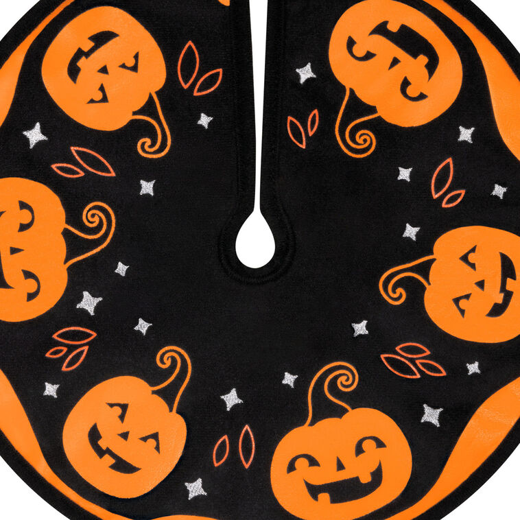 Mini Halloween tree skirt with orange and black design, smiling jack-o’-lanterns, and embroidered accents
