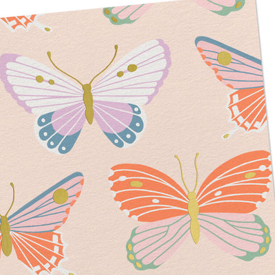 Blank note cards with colorful butterfly illustrations and gold foil accents on a soft peach background.