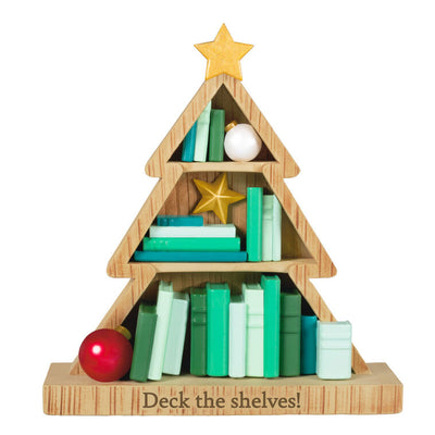 Tree-shaped wooden bookcase ornament filled with green books, red and white ornaments, and gold star accents

