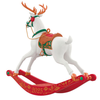 White reindeer Christmas ornament with bronze antlers and hooves, red flower accents, green bridle, on rocking stand

