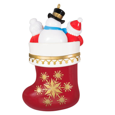 Hallmark Keepsake Stocking Stuffers ornament—red and white stocking with gold snowflakes, Santa, Mrs. Claus, and snowman in vintage style
