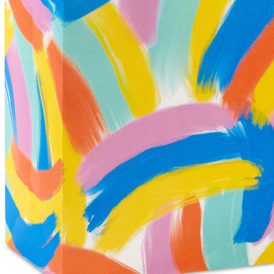 Hallmark medium gift bag with colorful abstract brushstroke rainbows in purple, blue, yellow, and orange on a white background