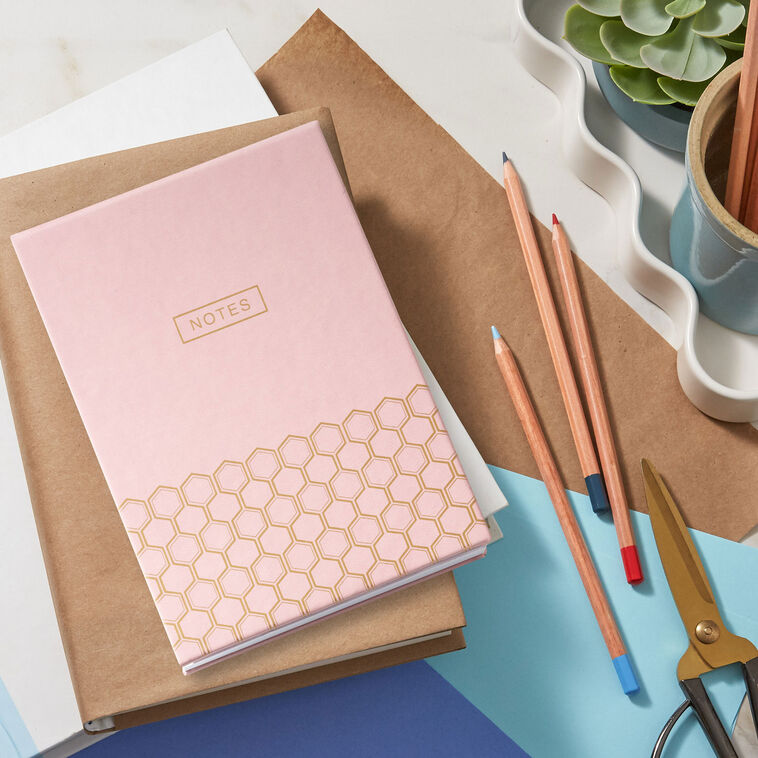Pastel pink faux leather list pad with gold foil honeycomb design and lined, perforated pages.
