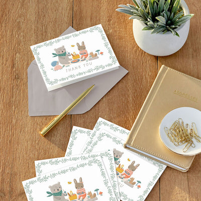 Baby thank you cards with bear and bunny picnic illustration framed by greenery, includes 10 blank white cards and kraft envelopes