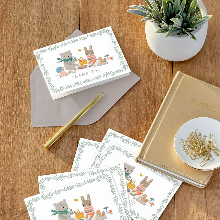 Baby thank you cards with bear and bunny picnic illustration framed by greenery, includes 10 blank white cards and kraft envelopes