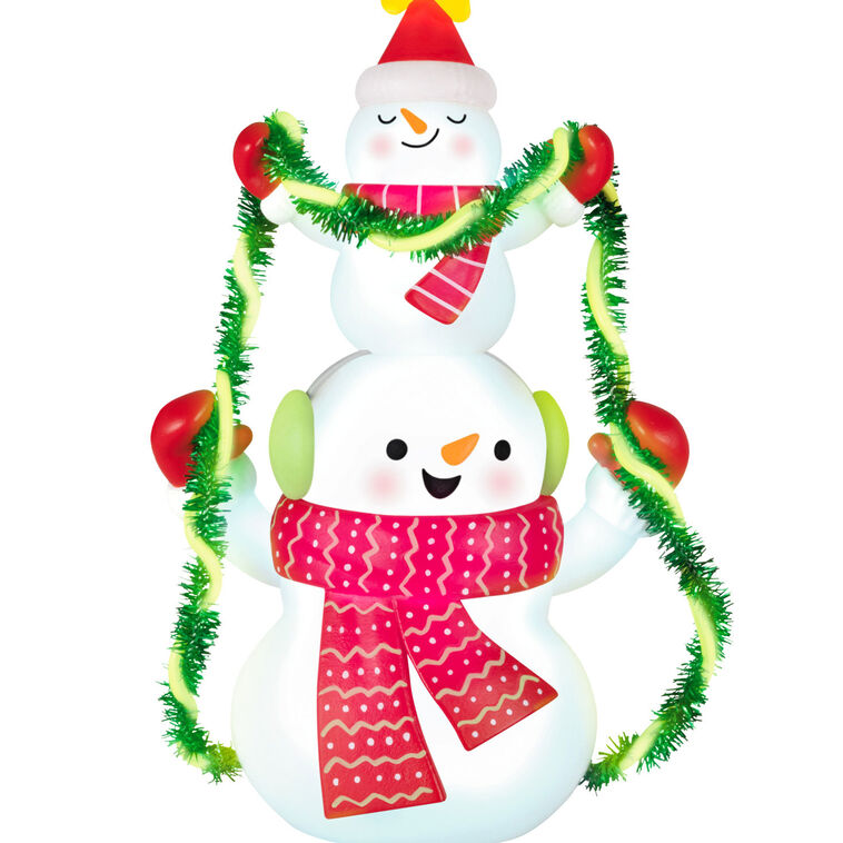 Stacked snowmen Christmas ornament wrapped in green tinsel garland with glowing star, battery operated light-up decor

