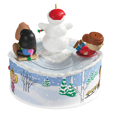 Peanuts Gang sledding ornament with Snoopy, Lucy, and snowman, light-up musical Christmas scene, Hallmark Keepsake motion collectible
