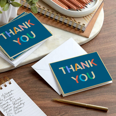 Colorblock thank-you cards with multicolor lettering on navy blue background and gold foil accents.
