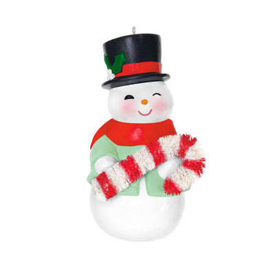 Porcelain snowman ornament in festive coat, scarf, and top hat holding a bottlebrush candy cane