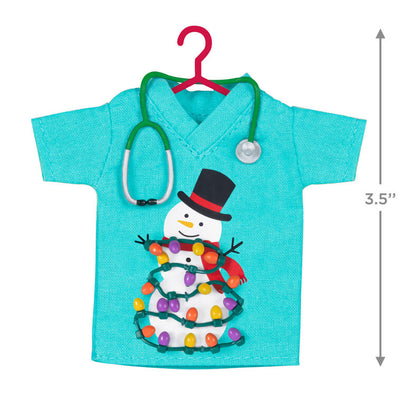 Teal fabric scrubs ornament with snowman and Christmas lights, stethoscope detail, honoring healthcare workers

