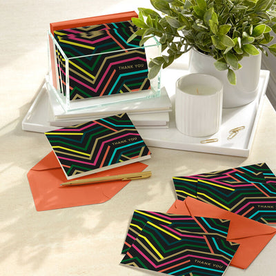 Black thank-you cards with angular neon lines in bold colors and gold foil lettering.
