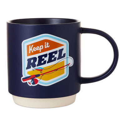 Midnight blue ceramic mug with "Keep it reel" pun, fishing rod and lure design, oversized handle, and recessed stacking base.