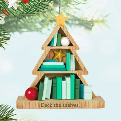 Tree-shaped wooden bookcase ornament filled with green books, red and white ornaments, and gold star accents


