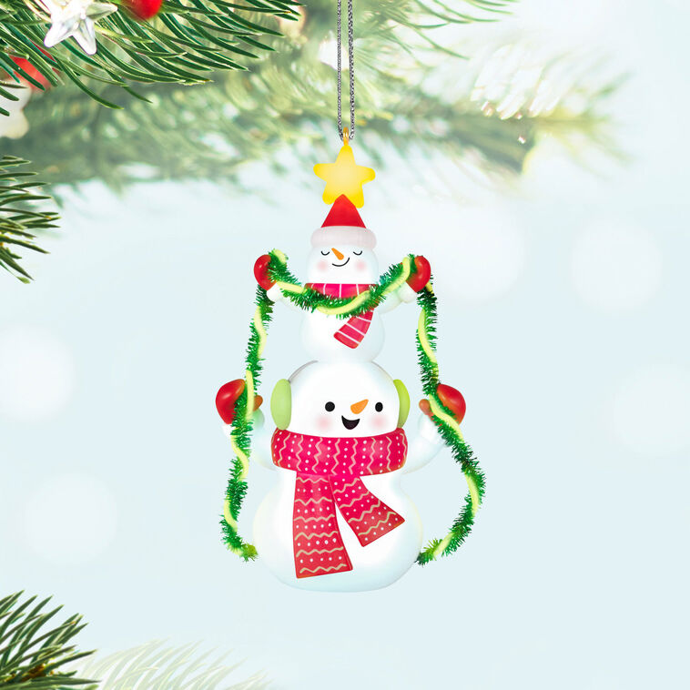 Stacked snowmen Christmas ornament wrapped in green tinsel garland with glowing star, battery operated light-up decor

