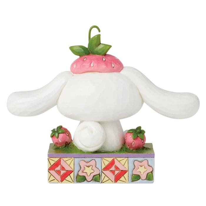 Jim Shore Cinnamoroll figurine sitting in grass with strawberries, hand-painted in folk art style bright Sanrio