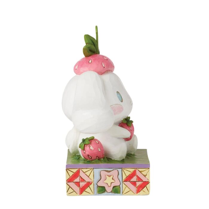 Jim Shore Cinnamoroll figurine sitting in grass with strawberries, hand-painted in folk art style bright Sanrio