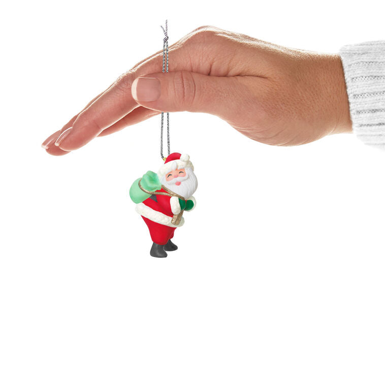 Mini Santa Claus ornament with rosy cheeks and green toy sack, retro-styled Hallmark Keepsake Christmas collectible