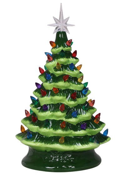16-inch green ceramic Christmas tree with multicolored lights, placed on a table with a gray couch and holiday lights in the background