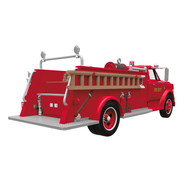 1968 red Chevrolet fire engine Christmas ornament with ladder details, turning wheels, and battery-powered light on front grill.