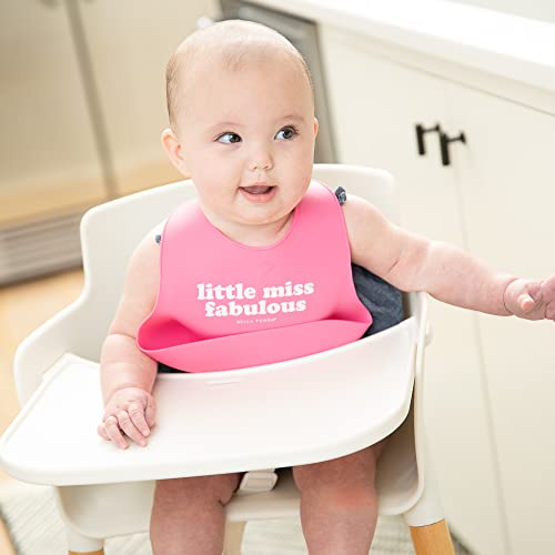 Soft silicone baby bib in pink with “Little Miss Fabulous” print and deep food-catching pocket, adjustable neck closure.

