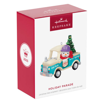 Hallmark Keepsake Holiday Parade 2025 ornament—snowman with “Word Nerd” hat drives bookshop pickup truck hauling Christmas tree made of books
