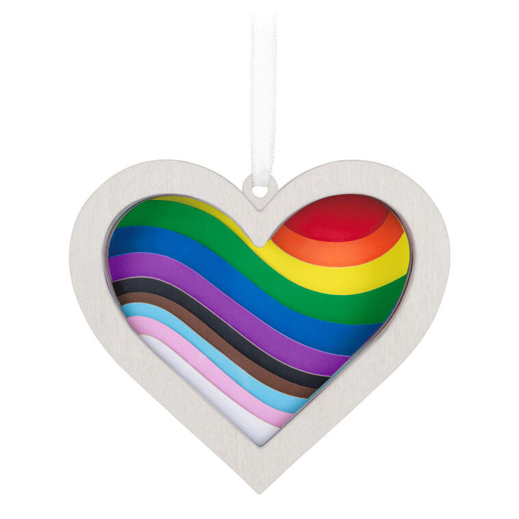Heart-shaped rainbow papercraft ornament in a whitewashed wood frame with “Love Wins” ribbon for LGBTQIA holiday celebration.