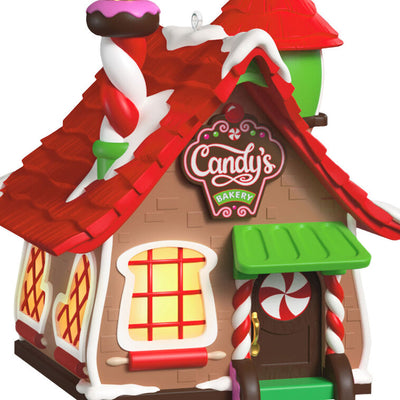 Two-piece ornament set with a festive bakery shaped like a gingerbread house and a smiling elf named Candy holding chocolate cake.