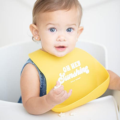 Bright yellow silicone baby bib with 'Oh Hey Sunshine' text and food-catching pocket.