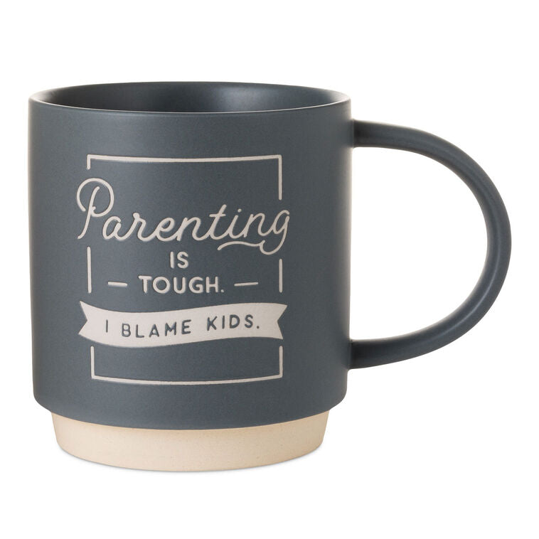 Blue-gray ceramic mug with white banner that reads “Parenting is tough. I blame kids,” oversized handle and stackable base.