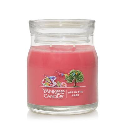 A medium Yankee Candle Art in the Park jar with vibrant pink wax and silver lid, featuring floral and fruity festival-inspired fragrance.