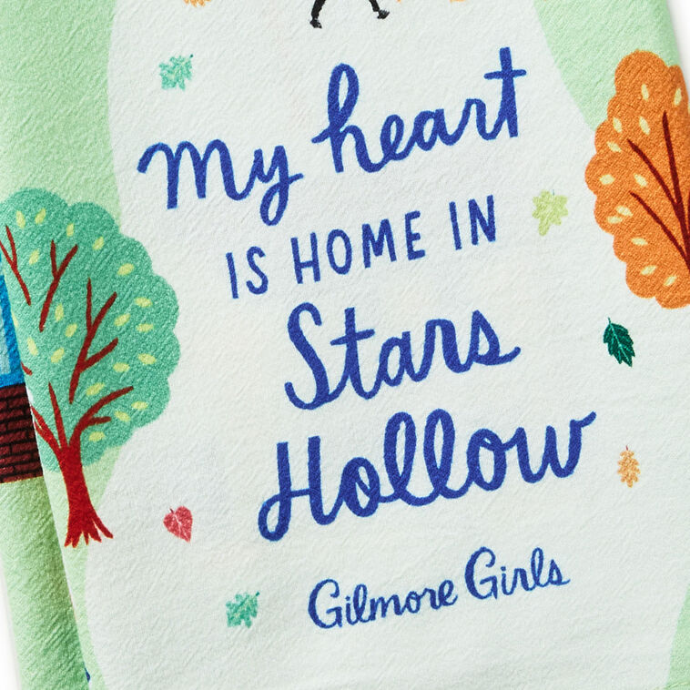 White tea towel printed with a whimsical Stars Hollow map and a central Gilmore Girls quote, includes a loop for hanging.
