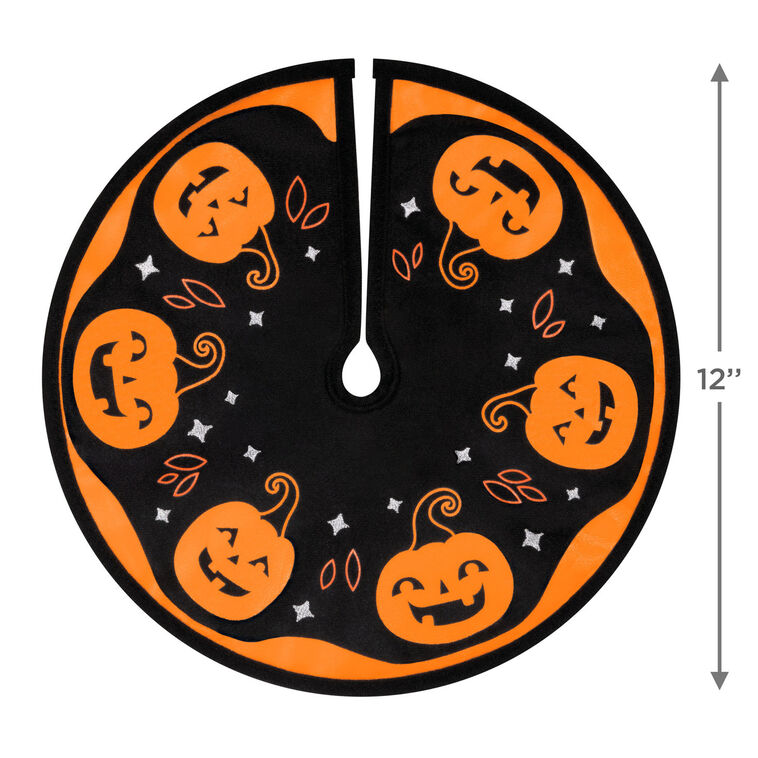 Mini Halloween tree skirt with orange and black design, smiling jack-o’-lanterns, and embroidered accents

