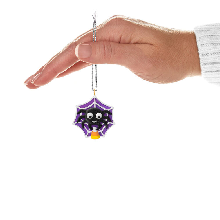 Mini Halloween spider ornament holding candy corn in sparkly web, perfect for tabletop tree display
