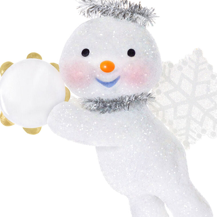 Glittery snow angel snowman ornament with tinsel halo, snowflake wings, rosy cheeks, and holding a tambourine


