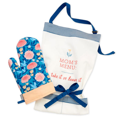 White apron with pink 'Mom's Menu: take it or leave it' embroidered message and blue accents, paired with a matching blue floral oven mitt.

