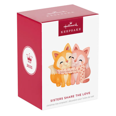 2025 Christmas ornament with two foxes snuggled in a heart-patterned scarf, celebrating sisterly love

