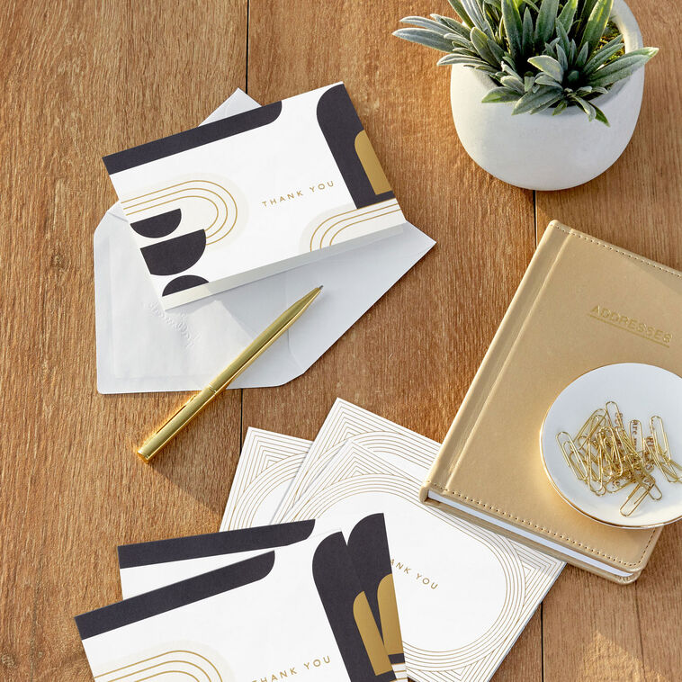 Assorted thank-you cards with modern gold foil ovals and abstract black and ivory shapes on white.
