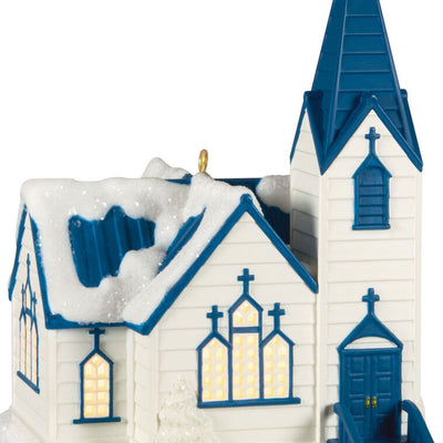 White church ornament with blue roof, steeple, and glowing windows, designed to light up with miniature Christmas light string.